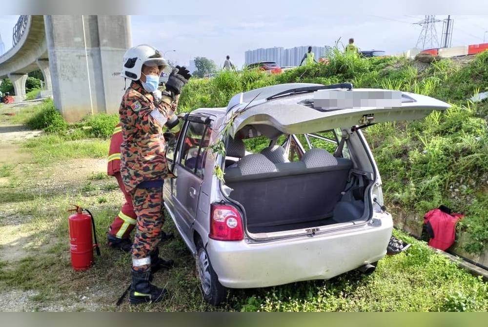 Anggota bomba ketika menjalankan kerja-kerja mengeluarkan mangsa yang maut dalam kemalangan berhampiran susur keluar Desa Water Park di Kilometer 2.2 Lebuh Raya Seremban menghala ibu kota pada Selasa.