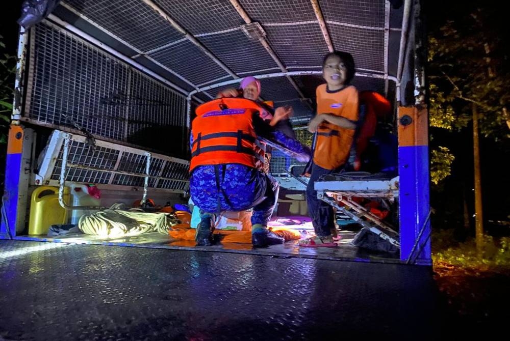 Anggota APM melakukan kerja-kerja pemasangan kubikal di salah sebuah PPS yang di buka ekoran banjir kilat melanda tiga kampung di Raub pada Khamis. - Foto APM