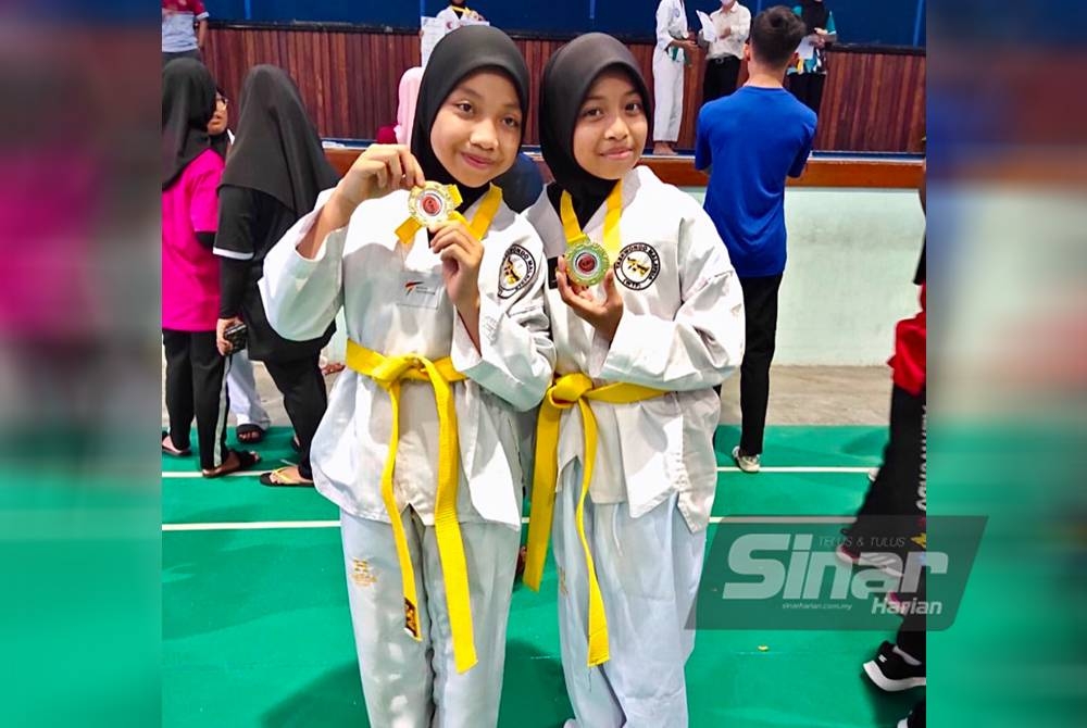 Nur Ishamina (kiri) dan Khasif Adriana (kanan) menang emas kejohanan taekwondo sempena Program 1,000 Liga tahun 2022 peringkat daerah di Kompleks Sukan Panji Kota Bharu pada Sabtu.