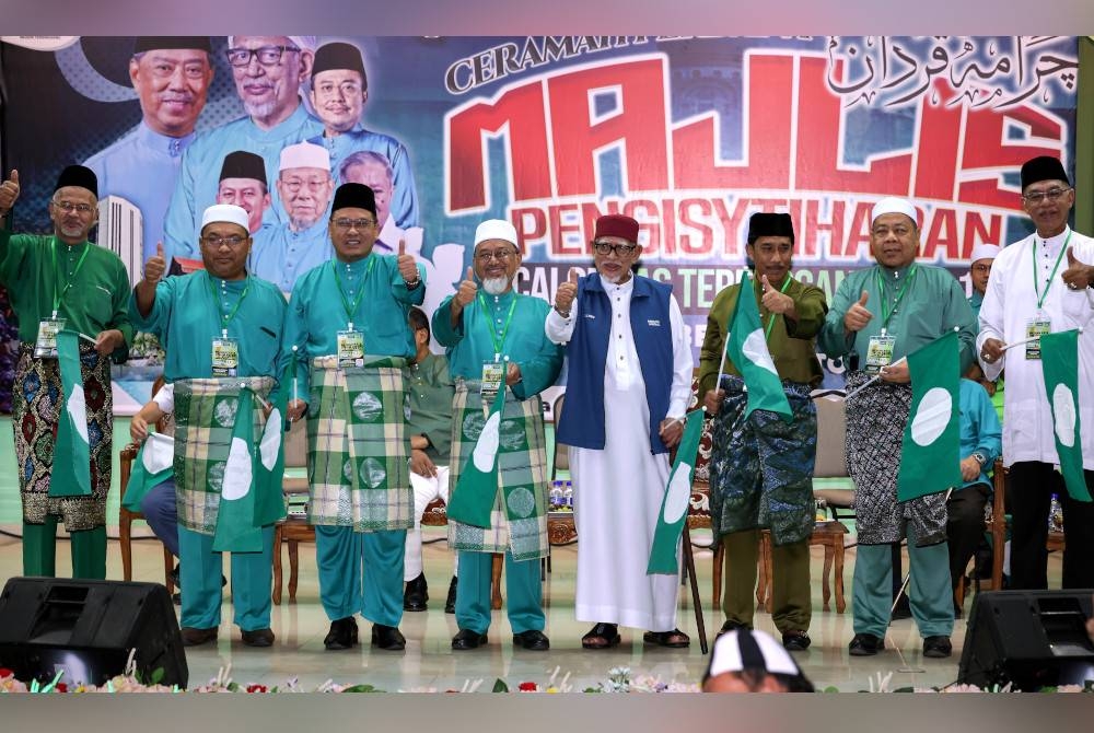 Abdul Hadi Awang (empat dari kanan) bergambar bersama calon-calon PN pada Pengisytiharan Calon PN PRU15 di Rusila malam ini.
