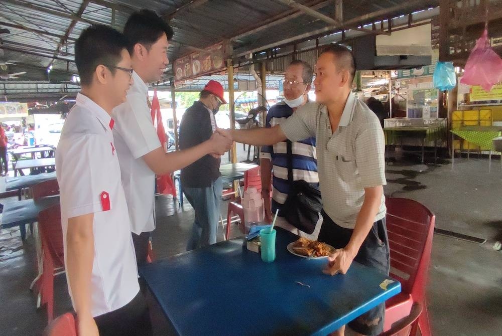 Calon Pakatan Harapan (PH) bagi kerusi Parlimen Alor Setar, Simon Ooi Tze Min (dua,kiri) beramah mesra dengan penduduk ketika sesi walkabout di Pasar Simpang Kuala, di sini, pada Jumaat.