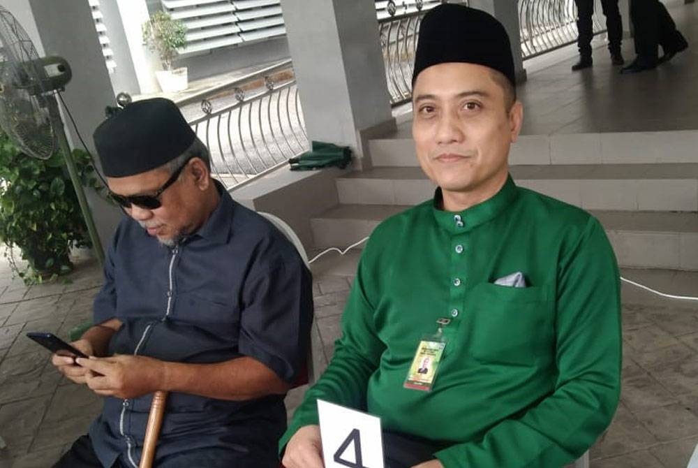 Fariz (kanan) memegang nombor giliran seperti yang dipegang oleh calon-calon lain sebelum dilihat keluar masuk ke dalam dewan.