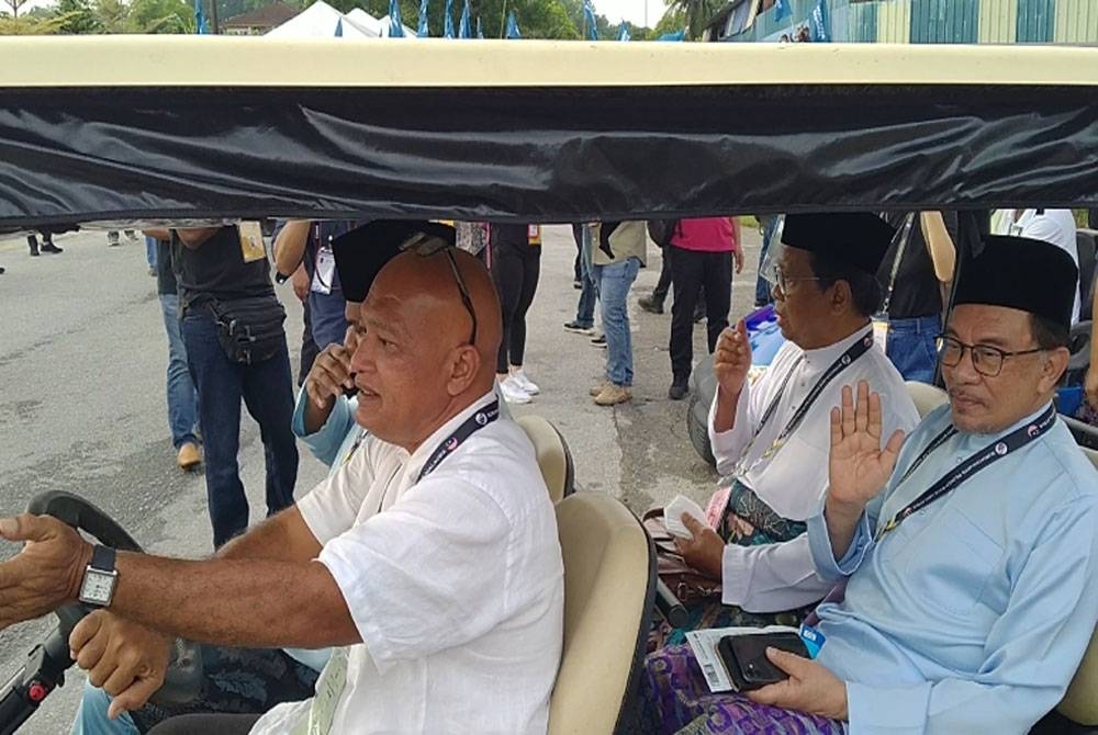 Anwar (kanan) bersama calon PH di kerusi Parlimen Tambun dibawa menaiki &#039;buggy&#039; ke Pusat Penamaan Calon di Dewan Sri Kledang, Institut Latihan Perindustrian Ipoh di sini pada Sabtu.