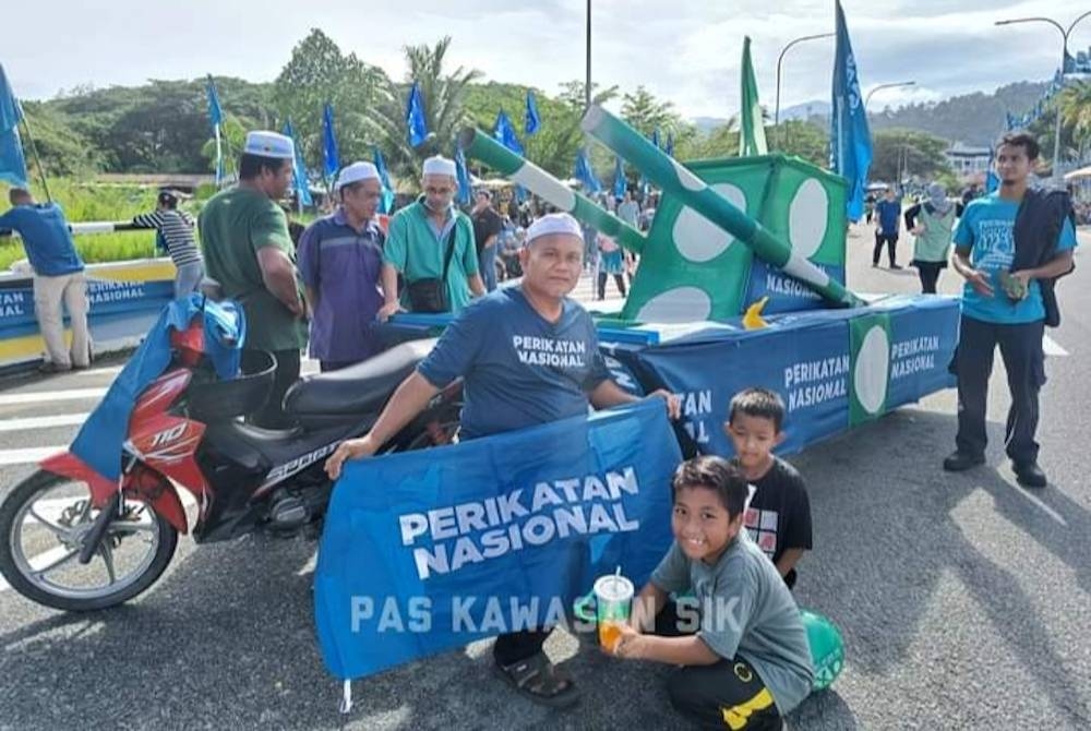 Orang ramai bergambar bersama replika &#039;kereta perisai&#039; yang dibawa bagi memeriahkan hari penamaan calon di Parlimen Sik. - Foto FB Pas Kawasan Sik-Laman Rasmi