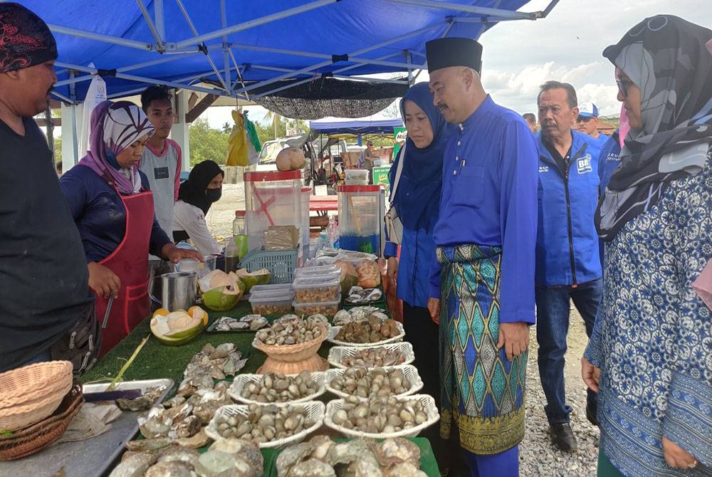 Abd Rahman (dua dari kanan) beramah mesra bersama penjual dan pengunjung semasa lawatannya ke Pantai Bagan Nakhoda Omar pada Ahad.