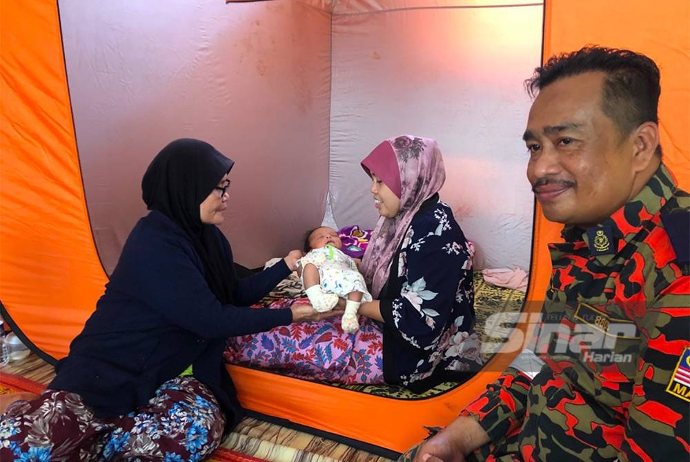 Narizan (kiri) menyerahkan Muhamad Aidel Rafael kepada Zulkartini di PPS SK Gual To’Deh, Rantau Panjang. - Foto Sinar Harian