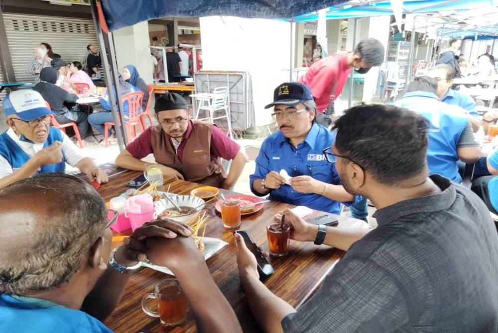 Johari (tiga dari kiri) bersama penduduk di Pasar dan Pusat Penjaja Wirawati, Kampung Pandan pada Ahad.