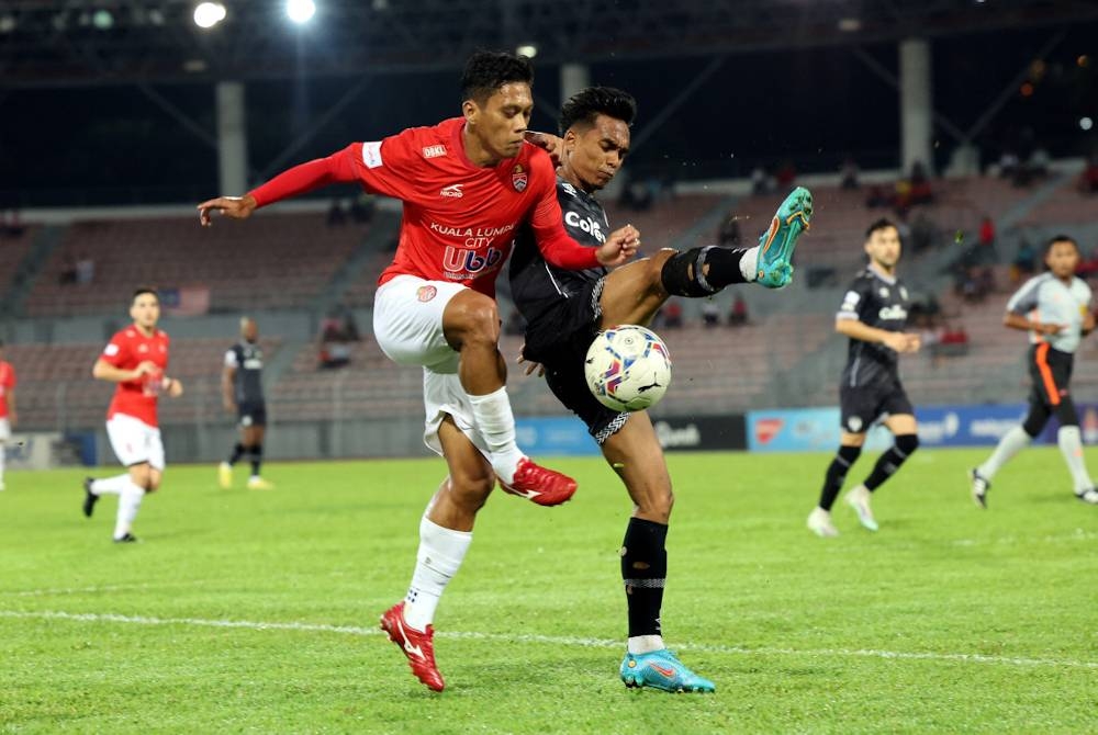 Pemain KL City, Mohamad Kamal Azizi Mohamad Zabri (kiri) diasak pemain TFC Muhammad Alif Zakaria dalam suku akhir pertama Piala Malaysia di Stadium Bola Sepak Kuala Lumpur pada Ahad.