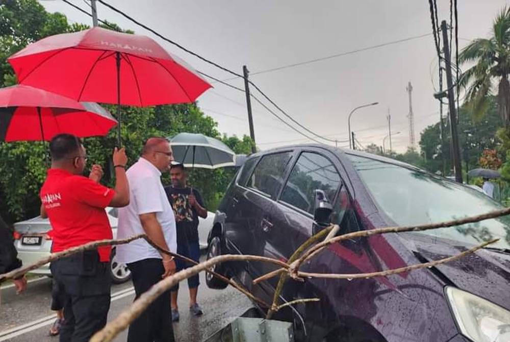 Sathia Prakash (dua dari kiri) melihat keadaan kereta mangsa terbabit kemalangan.