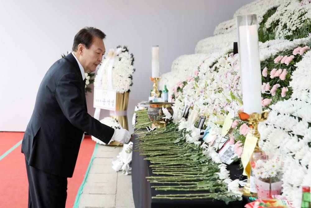 Yoon Suk-yeol meletakkan sekuntum bunga di altar peringatan di hadapan Dewan Bandaraya di Seoul, Korea Selatan pada 3 November lalu untuk memberi penghormatan kepada mangsa insiden rempuhan maut di Itaewon. - Foto EPA