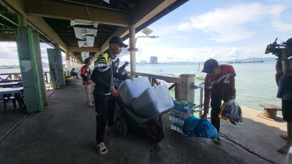 Mohd Izwan melakukan rutin hariannya mengangkat barang penduduk kampung dari Jeti Balembang untuk dihantar ke stesen bas Pulau Bum-Bum.