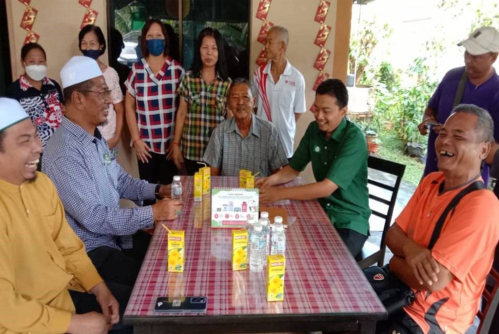 Mohd Syahir (duduk, dua dari kanan) bertemu masyarakat Siam Bachok di Kampung Balai, pada Isnin.