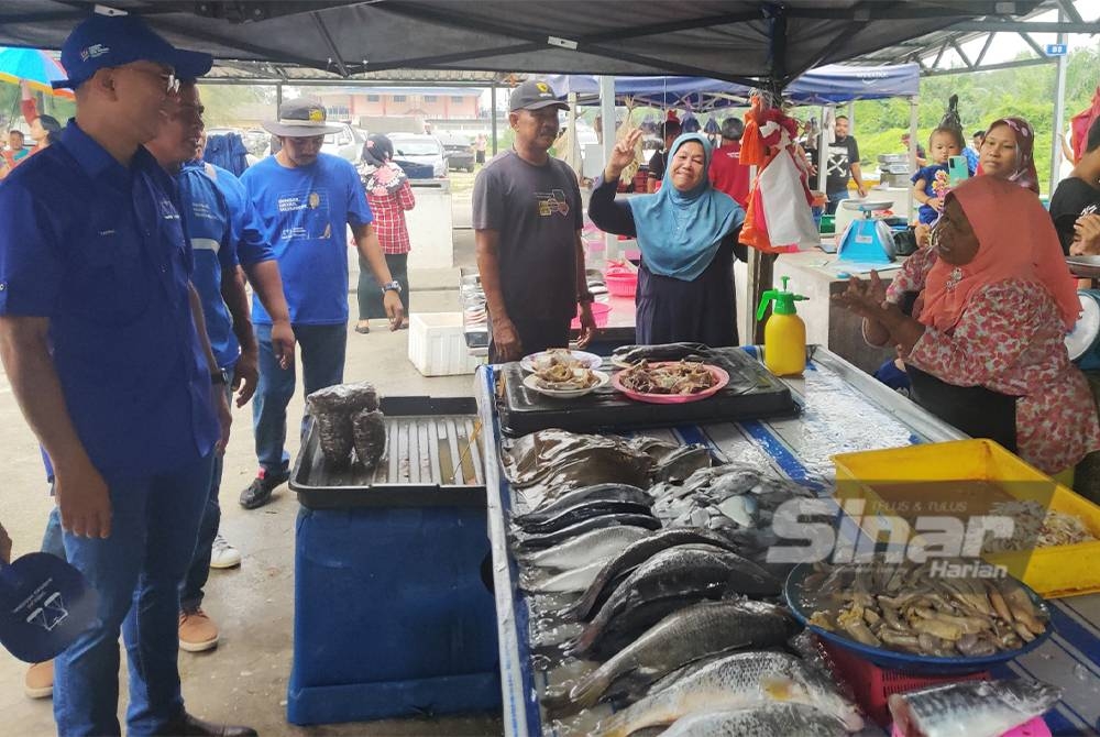 Tengku Zafrul (kiri) bertemu penjaja di Pantai Remis pada Isnin.