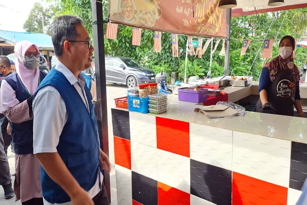 Mohd Ghazali (kiri) mengadakan sesi walk about di Kampung Paya Jaras Hilir, pada Isnin.