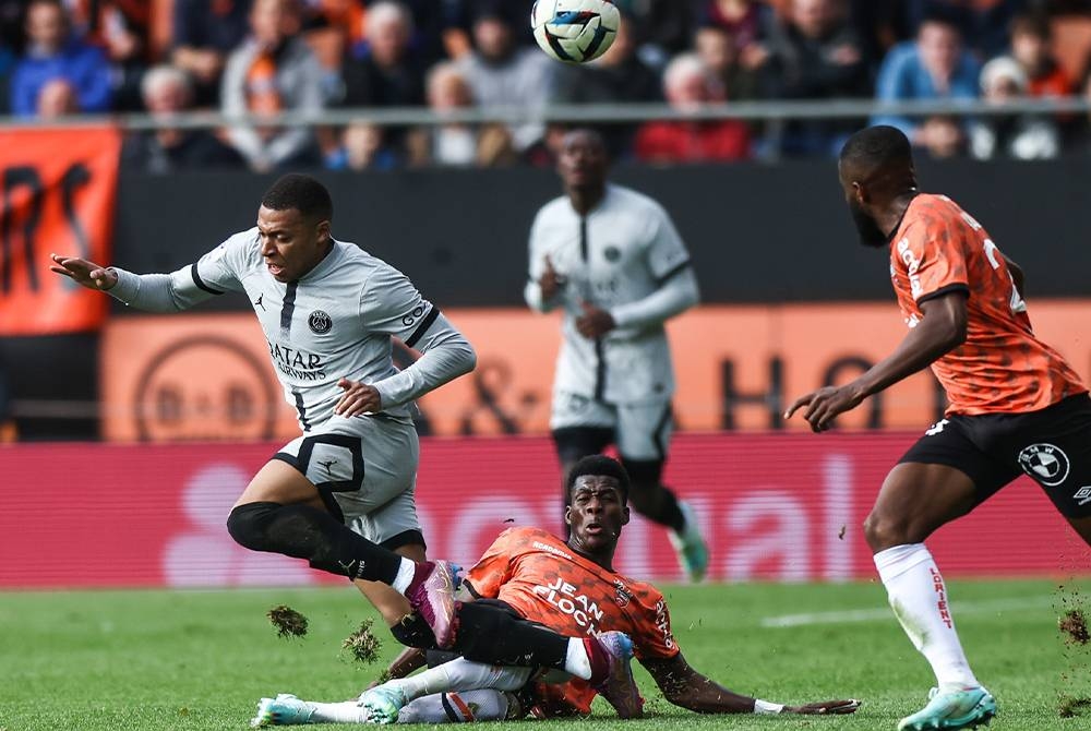 Mbappe (kiri) cuba melepasi kawalan pemain Lorient, Dango Ouattara dalam saingan Ligue 1 pada Ahad. - Foto EPA