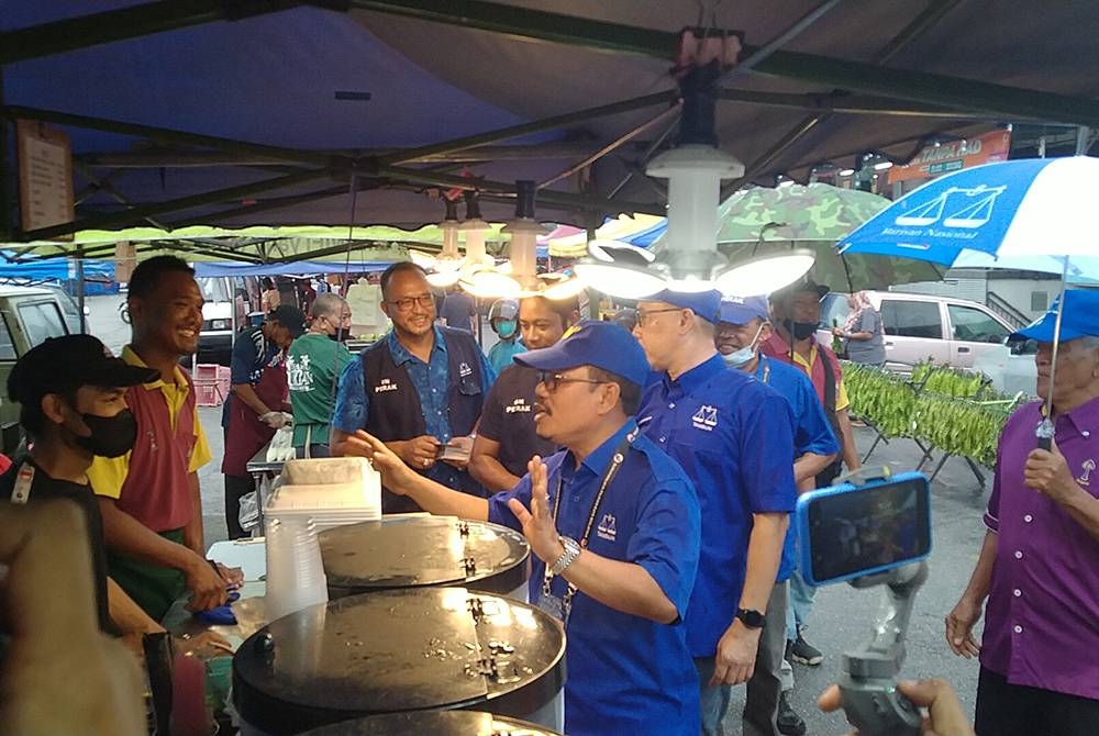 Hujan tidak menghalang calon-calon bertanding bertemu peniaga dan pengunjung pasar malam di Taman Perpaduan di sini pada Selasa.