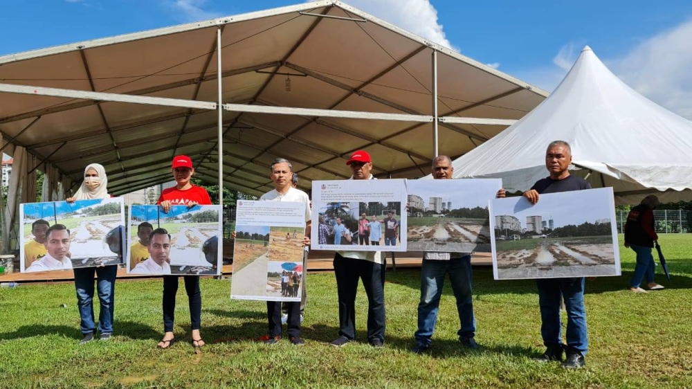 Fahmi (tiga dari kanan) menunjukkan bukti bergambar keadaan padang bola sepak di PPR Kerinci yang kurang sesuai untuk dijadikan pusat mengundi menggunakan khemah marquee.