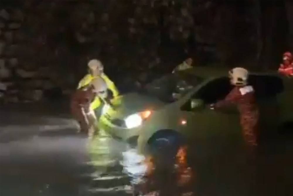 Anggota bomba dan polis membawa keluar kereta mangsa yang terperangkap di Jalan Chan Sow Lin pada Selasa. - Foto JSPT Kuala Lumpur