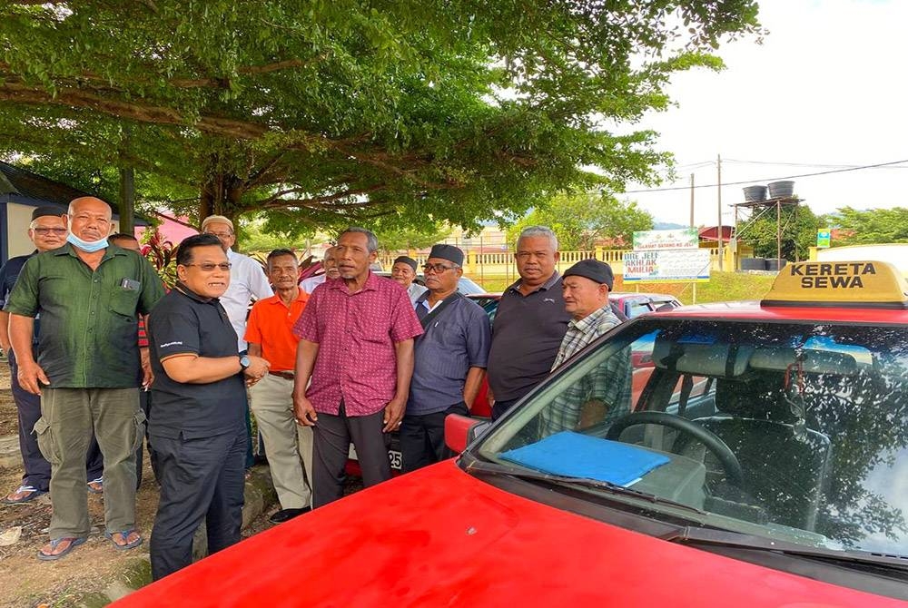 Zahari (dua dari kiri) turun padang bertemu dengan pemandu kereta sewa di Jeli pada Rabu.