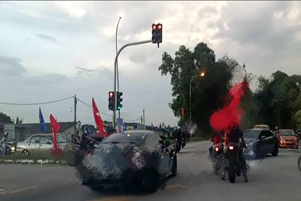 Tangkap layar video tular yang memaparkan sekumpulan penunggang bertindak sebagai marsyal di lampu isyarat Taman Desa Dahlia, Senawang, Seremban pada Isnin. - Foto media sosial