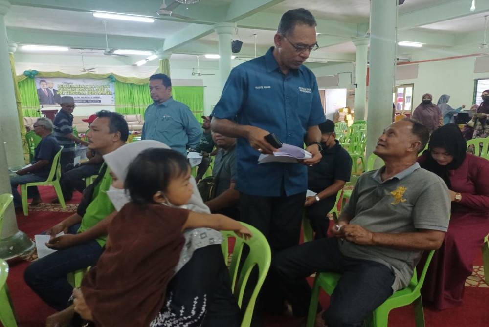 Rosol (berdiri) berbual dengan salah seorang penerima Bantuan Pencen Rakyat, OKU dan Ibu Tunggal DUN Manir di Kuala Terengganu pada Rabu.