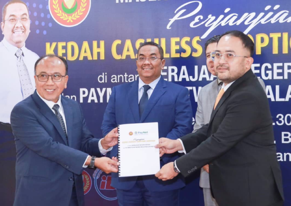 Muhammad Sanusi (tengah) menyaksikan pertukaran dokumen Kedah Cashless Adoption Campaign antara wakil kerajaan negeri dengan Payments Network Malaysia (Paynet) di Wisma Darul Aman pada Rabu.