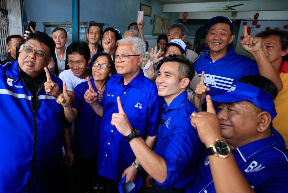 Perdana Menteri Datuk Seri Ismail Sabri Yaakob (tengah) meluangkan masa bergambar bersama para peniaga dan penduduk setempat semasa mengadakan Tinjauan Mesra di Pekan Durian Tunggal. - Foto Bernama