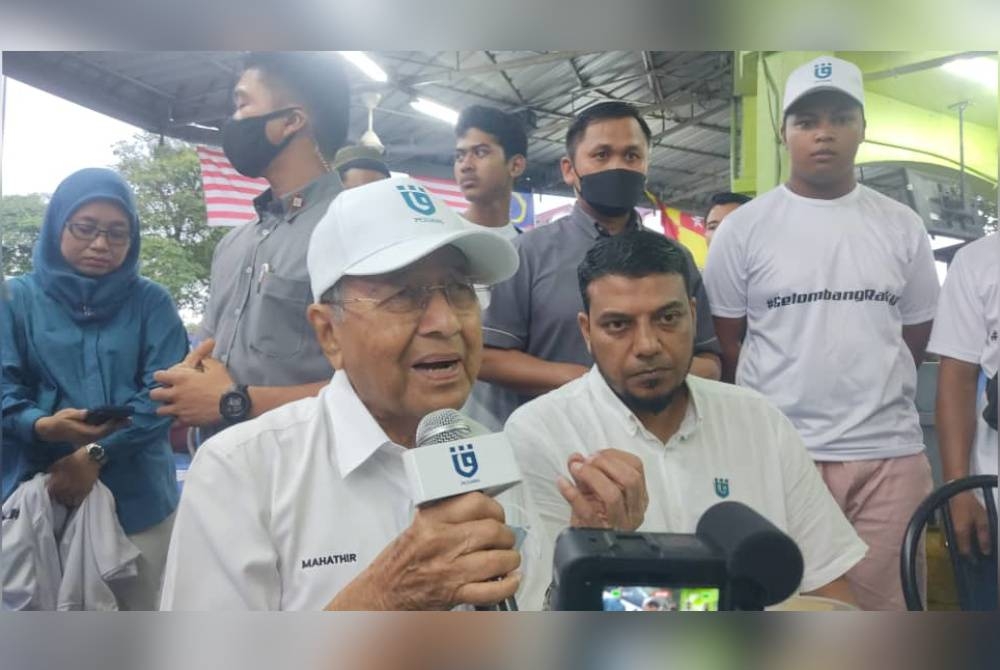 Mahathir (kiri) dan Rafique selepas bertemu pengundi di pasar malam Seksyen 24 pada Rabu.