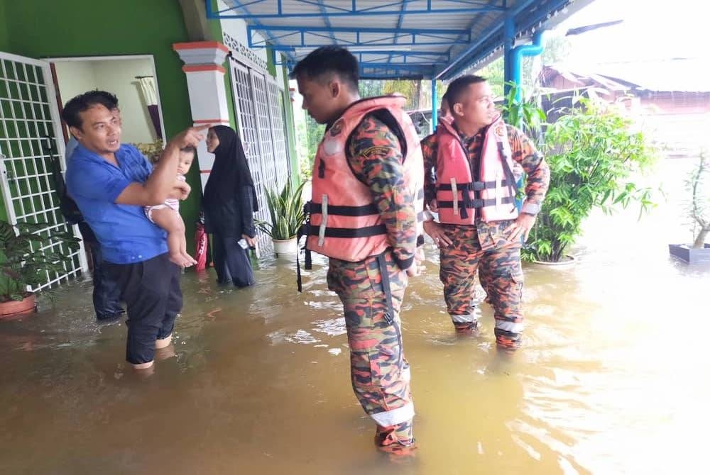 Anggota bomba membuat pemantauan di rumah penduduk di sekitar Meru yang dilanda banjir kilat pada Khamis.