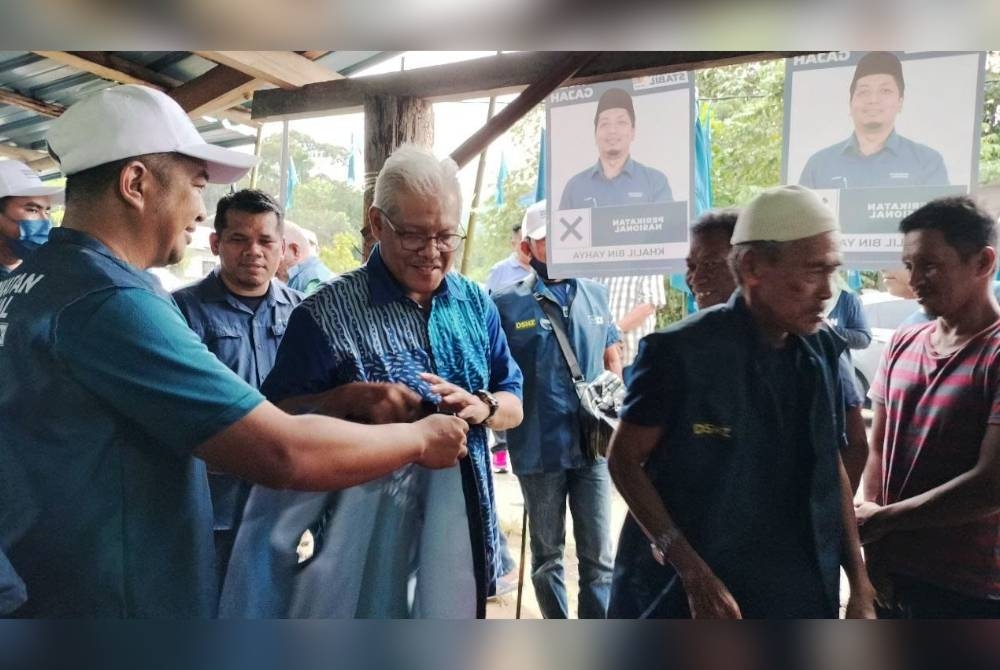 Hamzah menyerahkan jaket PN kepada petugas Pusat Daerah Mengundi (PDM) Kampung Sungai Jernih.