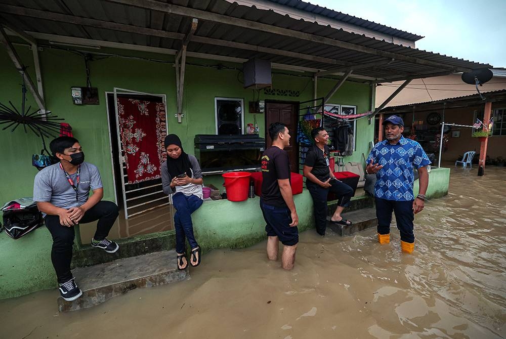 Khairy Jamaluddin melawat mangsa banjir kilat ketika meninjau keadaan beberapa rumah yang terjejas akibat banjir itu di kawasan Kampung Melayu Subang pada Khamis. - Foto Bernama