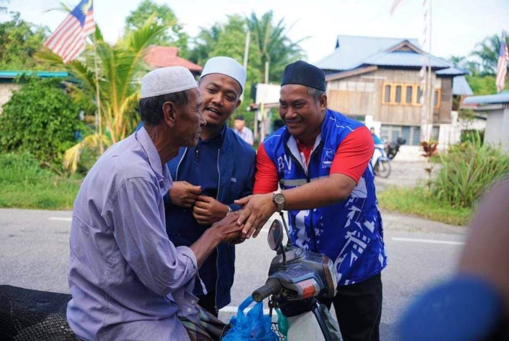 Nazirul (kanan) menyantuni pengundi DUN Gunung Semanggol sempena kempen PRU15 ini.