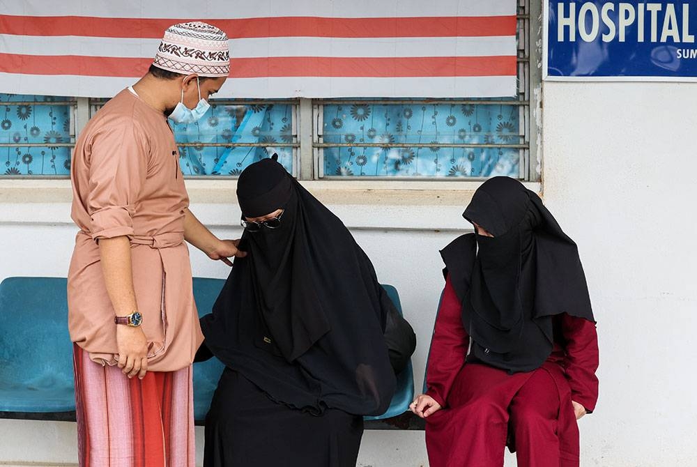 Nurul Syafiqah ditenangkan bapa dan ibu saudaranya. - Foto Bernama