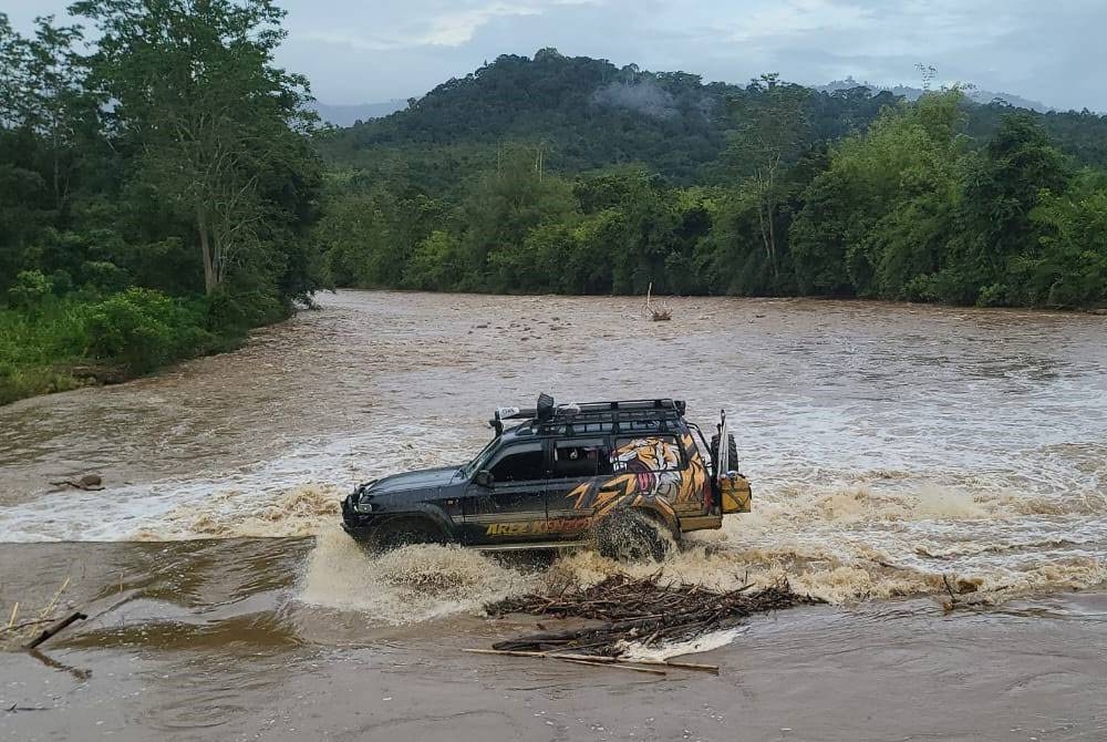 Matbali yang menaiki pacuan empat roda merentas jambatan yang dilimpahi arus deras di Sungai Meligan ketika melakukan jelajah kempen di Long Pasia, Sipitang.