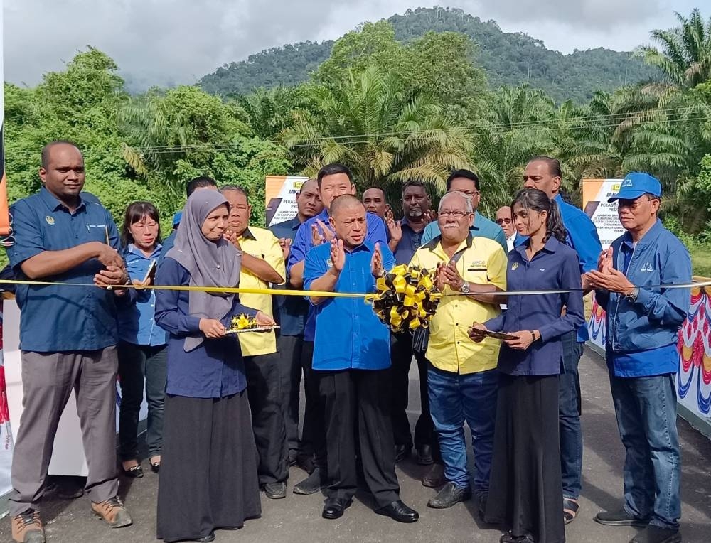 Saarani (tengah) merasmikan jambatan baharu Kampung Orang Asli Sungai Lah, Chenderiang, Tapah pada Ahad. 