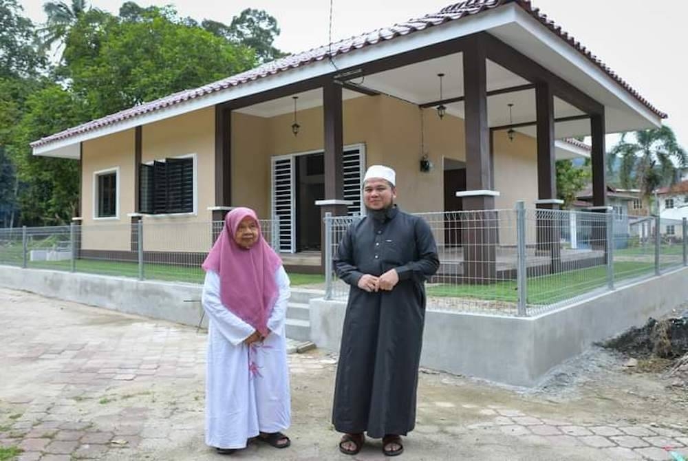 Ebit bersama Rohana di hadapan rumah baharu milik warga emas terbabit.