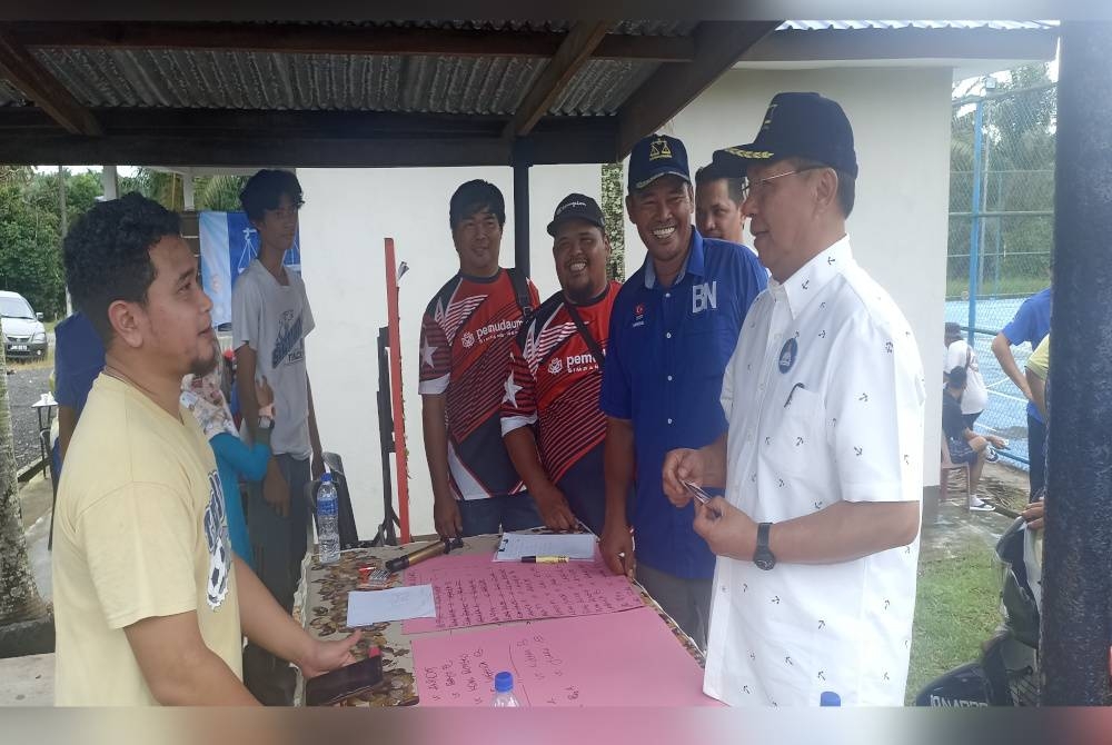 Hasni ( kanan) beramah mesra dengan penduduk pada program pertandingan futsal di Balai Raya Kampung Ibrahim Majid pada Ahad.