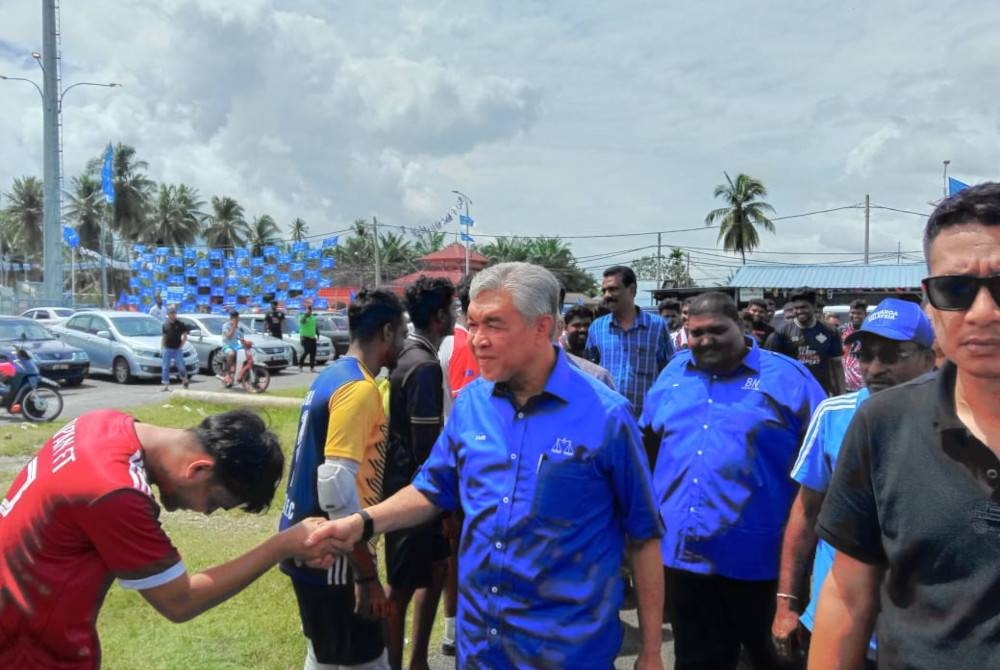 Ahmad Zahid bersalam dengan pemain futsal di Hutan Melintang, Bagan Datuk hari ini.