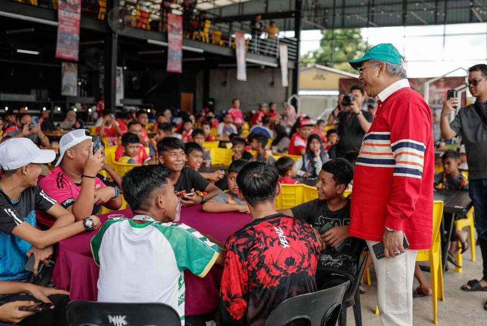 Annuar menyantuni penyokong The Red Warriors (TRW) pada Majlis Sambutan Ulangtahun 10 Tahun TRW Treble 2012 di Restoran Resepi Ikan Bakar hari ini. - Foto Bernama