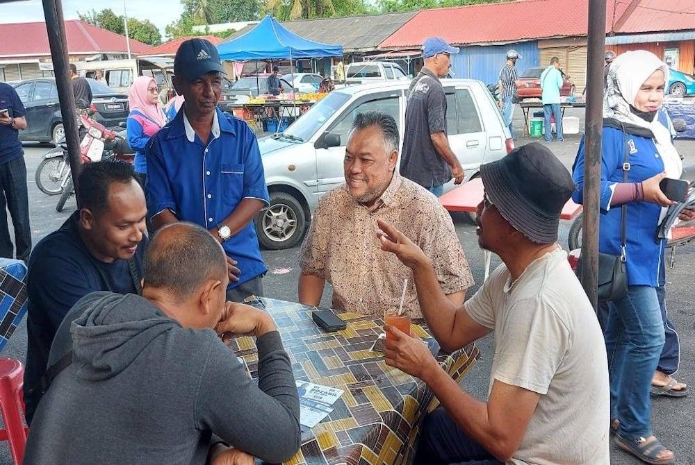 Rozabil (dua dari kanan) berbual dengan penduduk di sekitar Titi Chai pada Ahad.