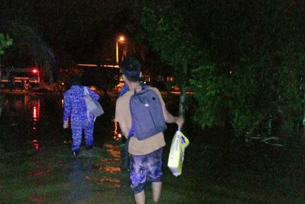 Anggota Angkatan Pertahanan Awam membantu mangsa terjejas banjir di Kampung Simpang 5 Darat Tangkak, berpindah ke PPS pada awal pagi Isnin.