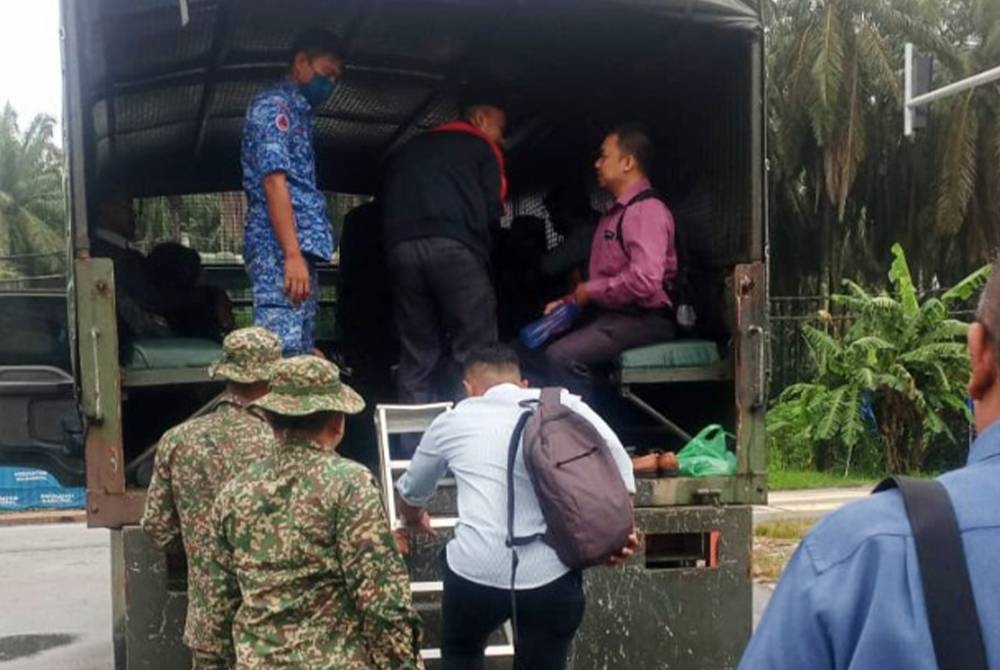 Kenderaan ATM digunakan bagi menghantar 10 guru ke SK Kumpulan Ganda pada pagi Isnin berikutan laluan masuk ke sekolah dinaiki air. - Foto APM Perak