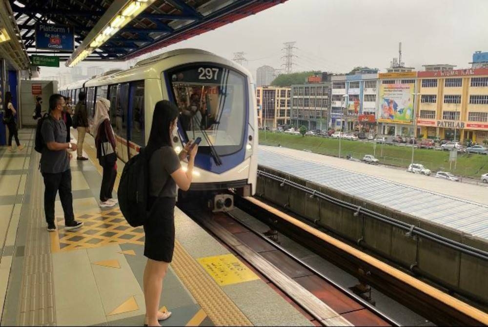 Antara pengguna yang menunggu tren di LRT Kelana Jaya pada pagi Isnin.