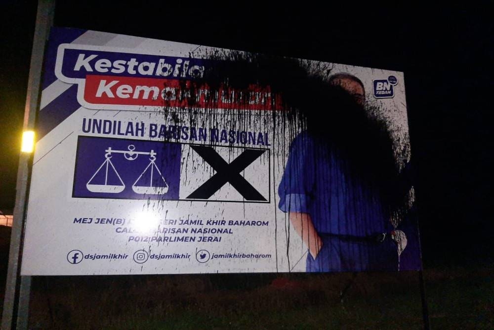 Poster calon BN Parlimen Jerai, Datuk Seri Jamil Khir Baharom disimbah dengan cat hitam di simpang empat Jalan Pulau Bunting, Yan pada malam Ahad. - Foto PDRM