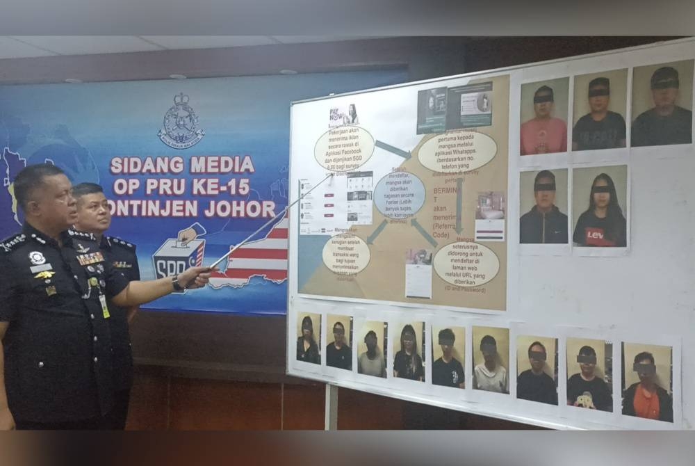 Kamarul Zaman menunjukkan gambar 14 anggota sindiket penipuan tawaran kerja atas talian pada sidang akhbar di IPK Johor pada Isnin.