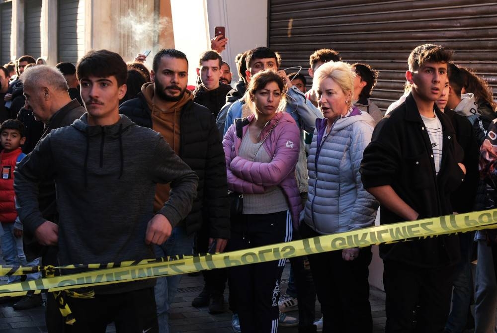 Orang ramai menyaksikan anggota polis Turkiye cuba mengamankan kawasan itu selepas letupan di Jalan Istiklal di Istanbul pada Ahad. - Foto EPA