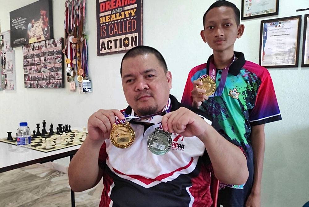 Norazlin (kiri) dan Faris Iqbal (kanan) menunjukkan pingat emas yang dimenangi di Para Sukma 2022 di Kuala Lumpur.