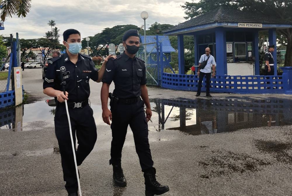 Abdullah Sidee (kiri) dibantu rakan selepas membuang undi di IPD Kuala Selangor pada Selasa.