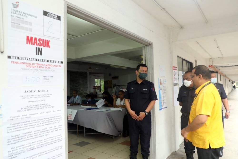 Deepak (kanan) hadir meninjau sekitar lokasi proses pengundian awal di Ibu Pejabat Polis Daerah Klang Selatan, Klang pada Selasa.