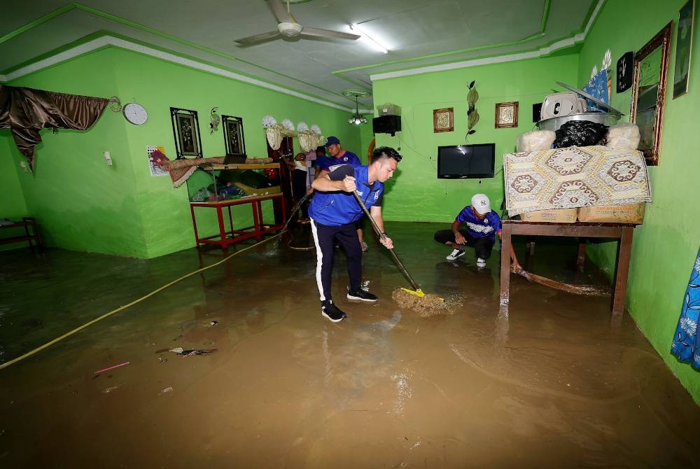 Calon BN Parlimen Kulai, Chua Jian Boon bersama sukarelawan BN turun padang membantu membersihkan rumah-rumah mangsa banjiar selepas air surut di Kampung Baru Sengkang, Kulai baru-baru ini.